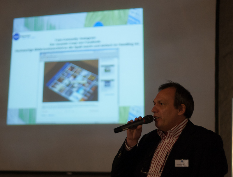 Radiomoderator Thomas Vatheuer mit Mikrofon vor einer Leinwand