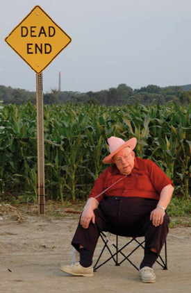 an older man is sitting on a chair